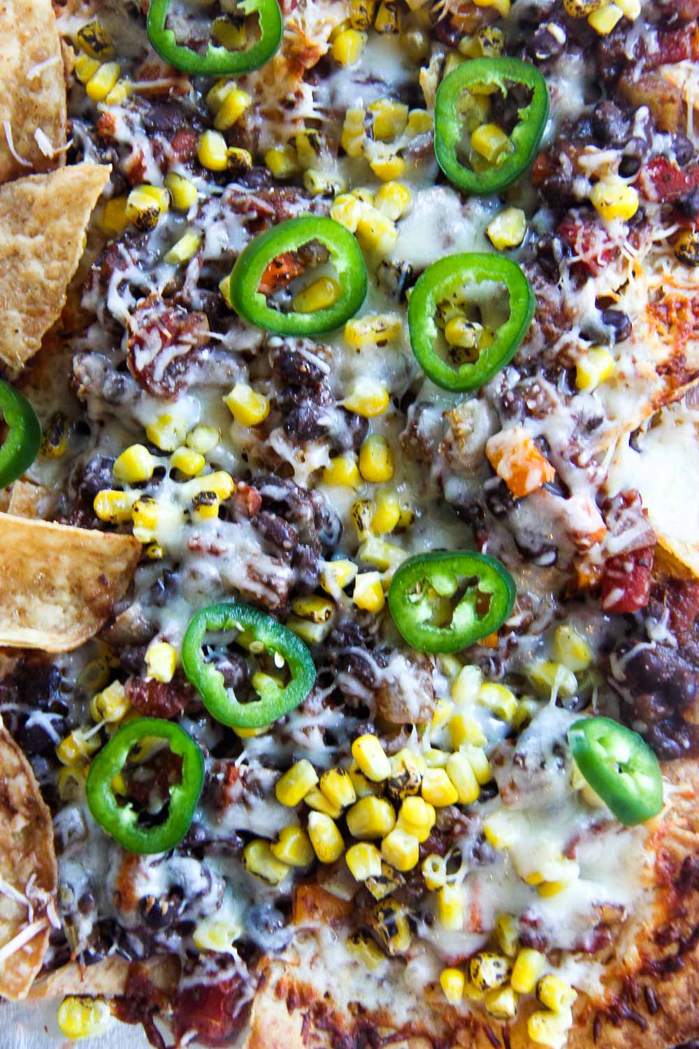 These Sheet Pan Black Bean Chili Nachos is an easy dinner or the ultimate party snack — you choose! Crispy, crunchy, salty, packed with flavor, and vegetarian-friendly.