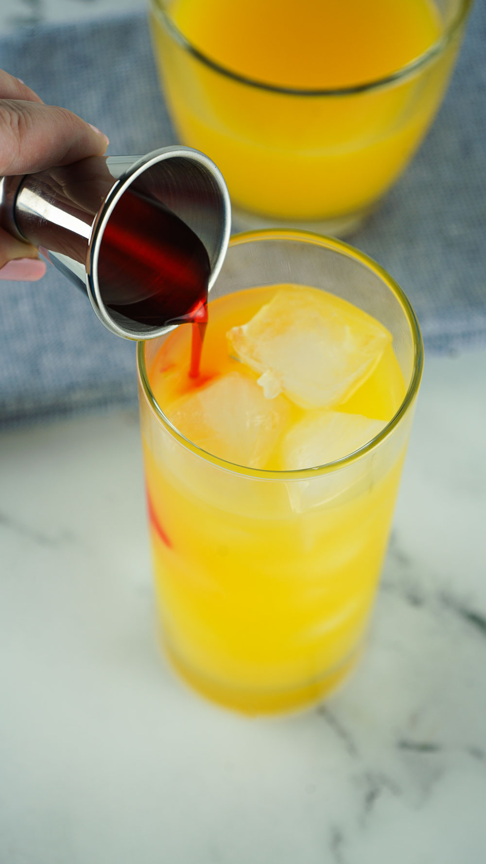 Best and refreshingly good tequila sunrise. This 3-ingredient classic cocktail never goes out of style! This drink is perfect for sipping by the pool or backyard parties and pairs wonderfully with easy pizza rolls, creamy asparagus puffs, and ham, egg, and cheese pockets. Learn how to easily layer a drink and enjoy this tropical cocktail with just a few ingredients.