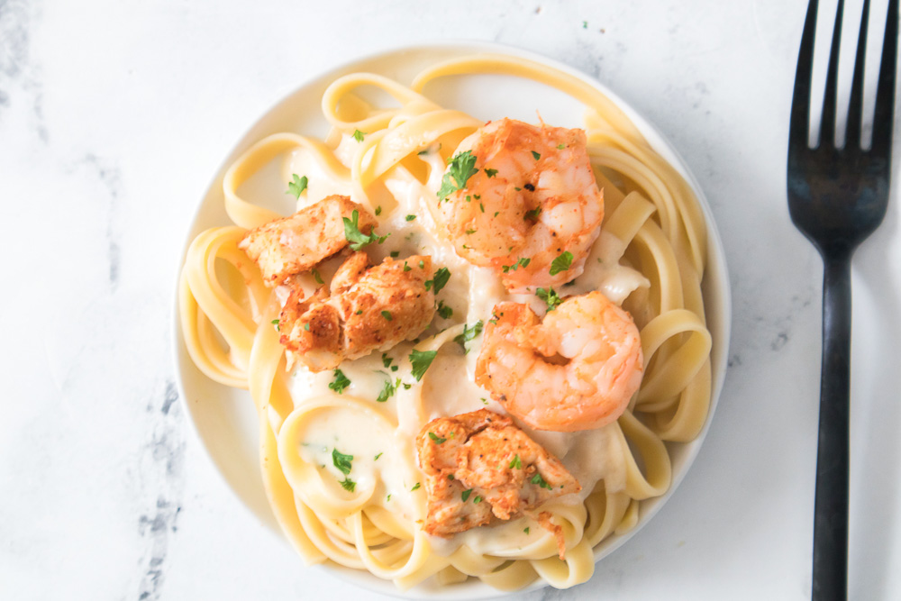 This air fryer chicken & shrimp alfredo pasta is rich in flavor and a family-friendly dinner you can get on the table in a matter of minutes! It’s a hearty meal that’s creamy and so easy to make.