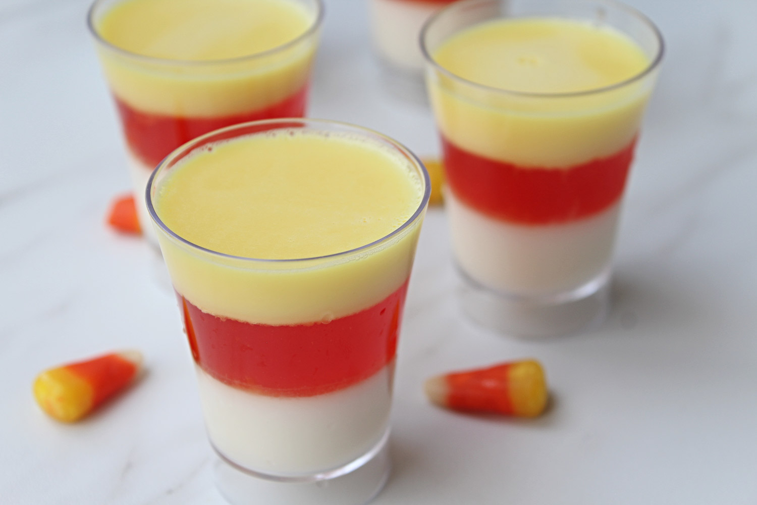 Fun, incredibly easy, and delicious; these candy corn Jello shots with Vodka make a tasty treat for your next Halloween. Not to mention that it's a hit with kids (be sure to skip the alcohol) and grown-ups (hello, Vodka jello shots!).
