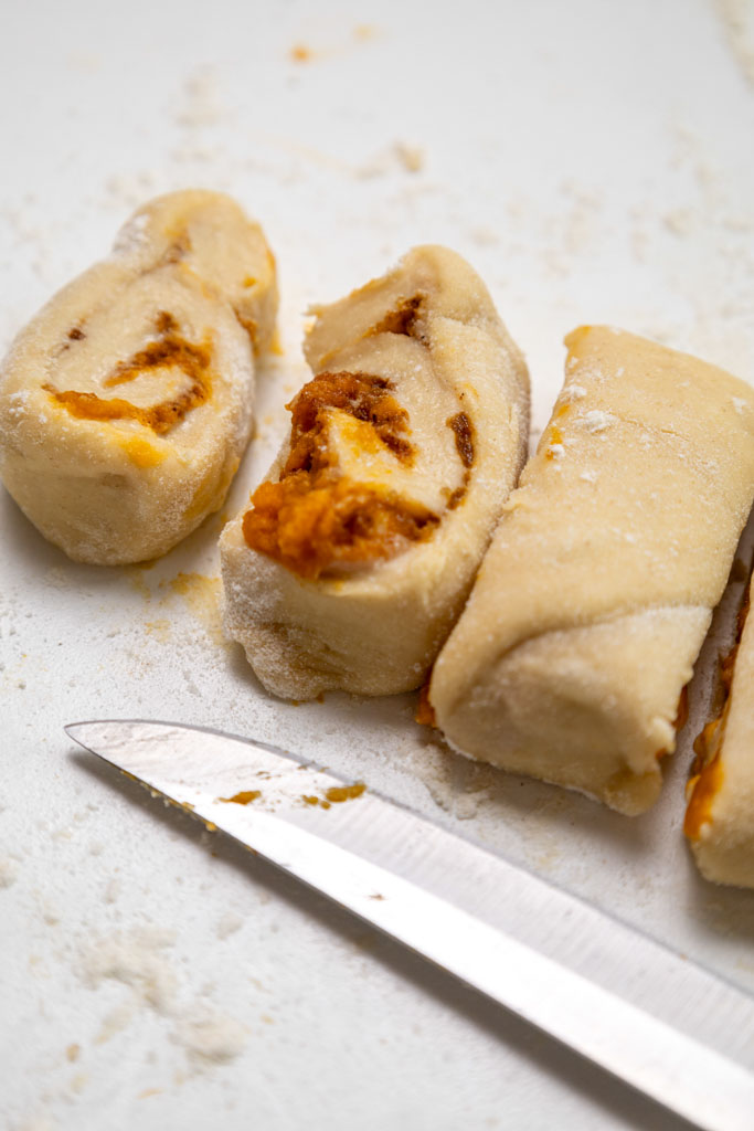 Fluffy homemade pumpkin cinnamon rolls topped with cream cheese pumpkin frosting
