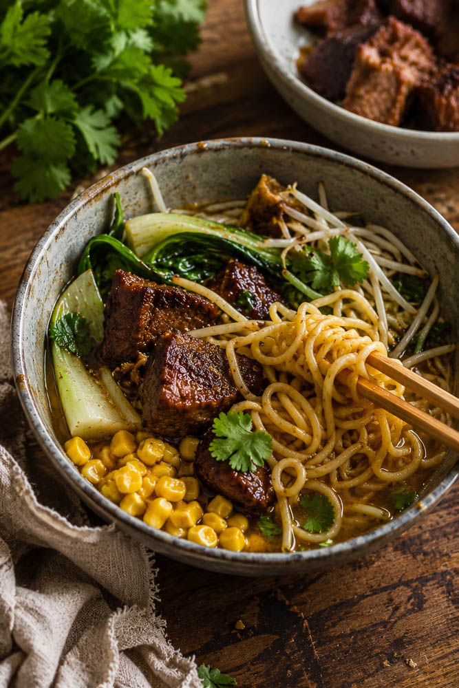 This Crockpot Caramelized Pork Noodle Soup combines fall-apart pork shoulder, a rich savory broth, tender noodles, and crispy-edged caramelized pork in one seriously cozy bowl.
