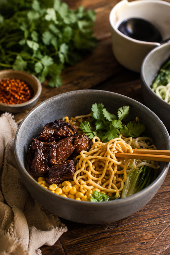 This Crockpot Caramelized Pork Noodle Soup combines fall-apart pork shoulder, a rich savory broth, tender noodles, and crispy-edged caramelized pork in one seriously cozy bowl.