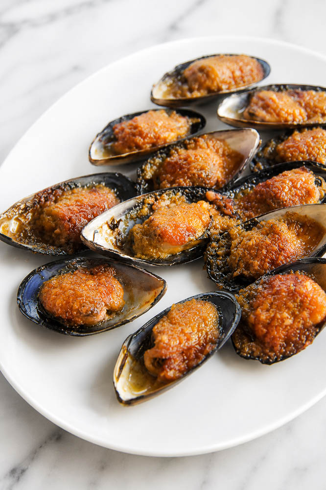 These Jimbaran-Style Grilled Mussels are topped with a buttery garlic sauce that’s sweet, savory, and slightly tangy, then broiled until the edges are bubbling and beautifully caramelized.