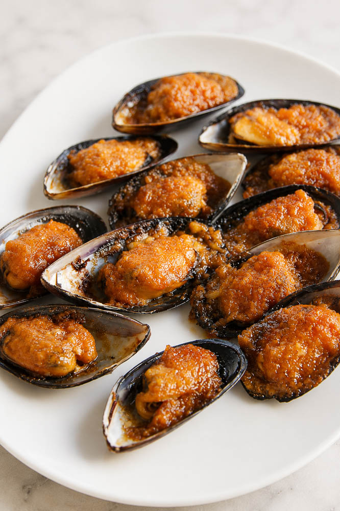 These Jimbaran-Style Grilled Mussels are topped with a buttery garlic sauce that’s sweet, savory, and slightly tangy, then broiled until the edges are bubbling and beautifully caramelized.