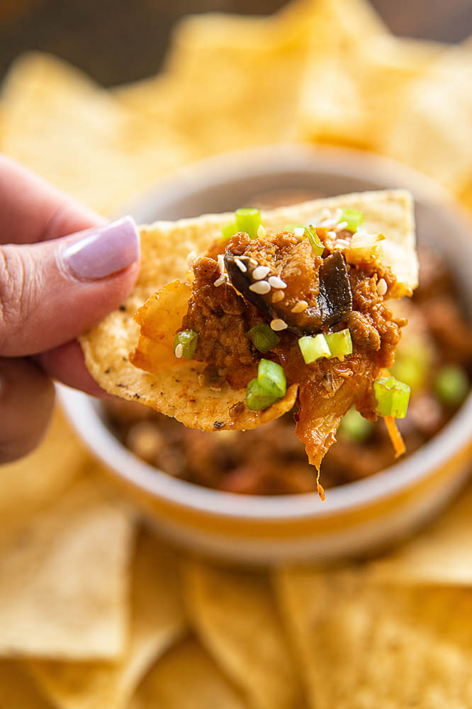 These Kimchi Eggplant Nachos pile crispy tortilla chips with savory ground pork, tender eggplant, and spicy, tangy kimchi for a Korean-inspired appetizer that is loaded with flavor and texture.
