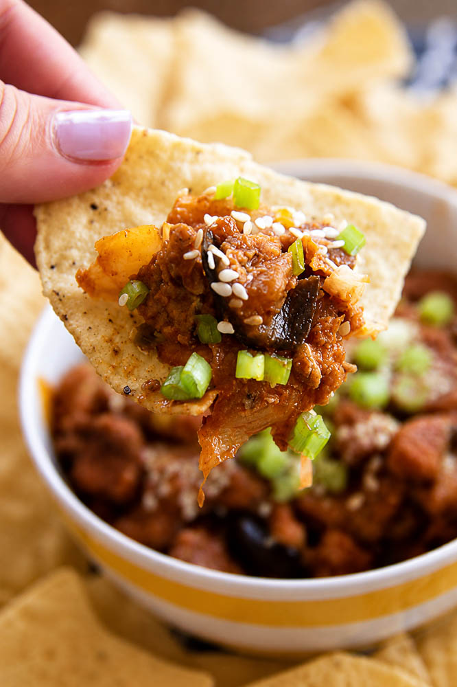 These Kimchi Eggplant Nachos pile crispy tortilla chips with savory ground pork, tender eggplant, and spicy, tangy kimchi for a Korean-inspired appetizer that is loaded with flavor and texture.